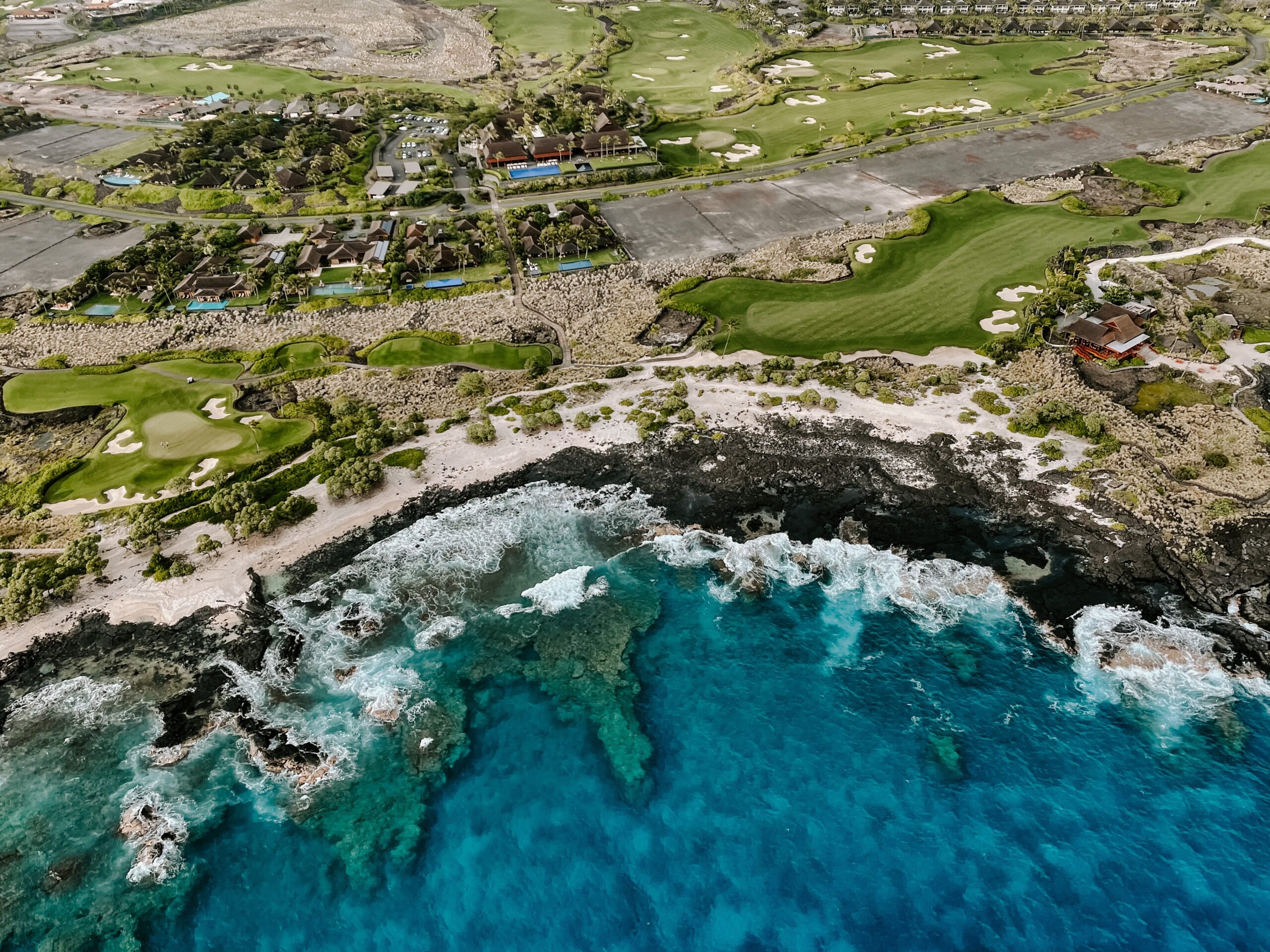 Aerial view of a golf resort on the lava rock coastline of the Kona side