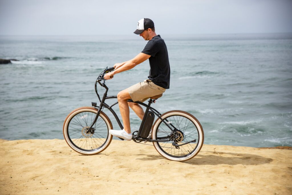 Cyclist riding along a beach road in Hawaii