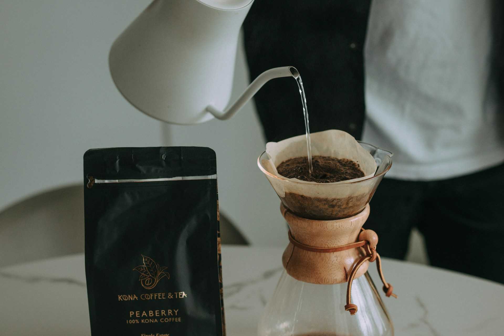 guy pouring hot water into a coffee filter to drink Kona coffee